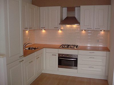Tweede geplaatste keuken met inbouwapparatuur en afgewerkte achterwand.